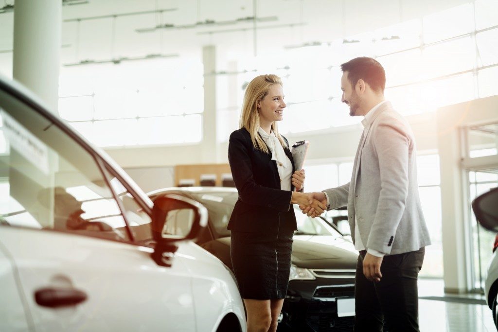 Salesperson with a client at a car dealership