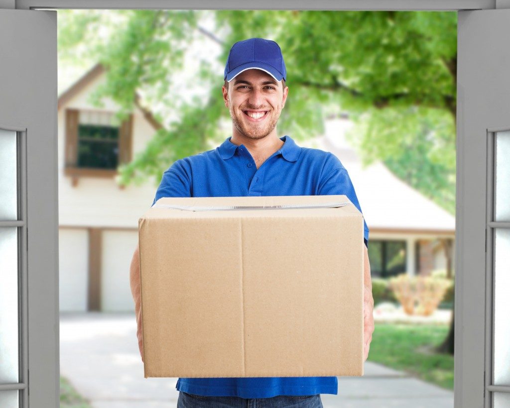 delivery man handing box to customer in a suburban village