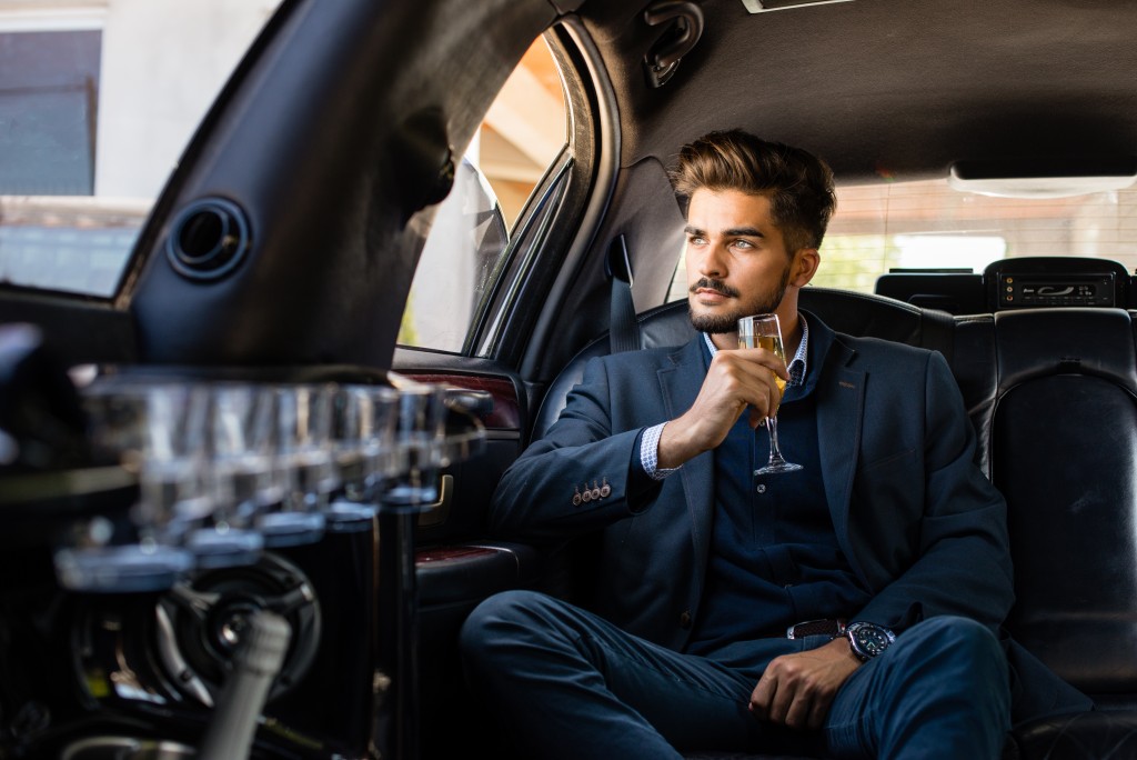 man drinking champagne in the limo
