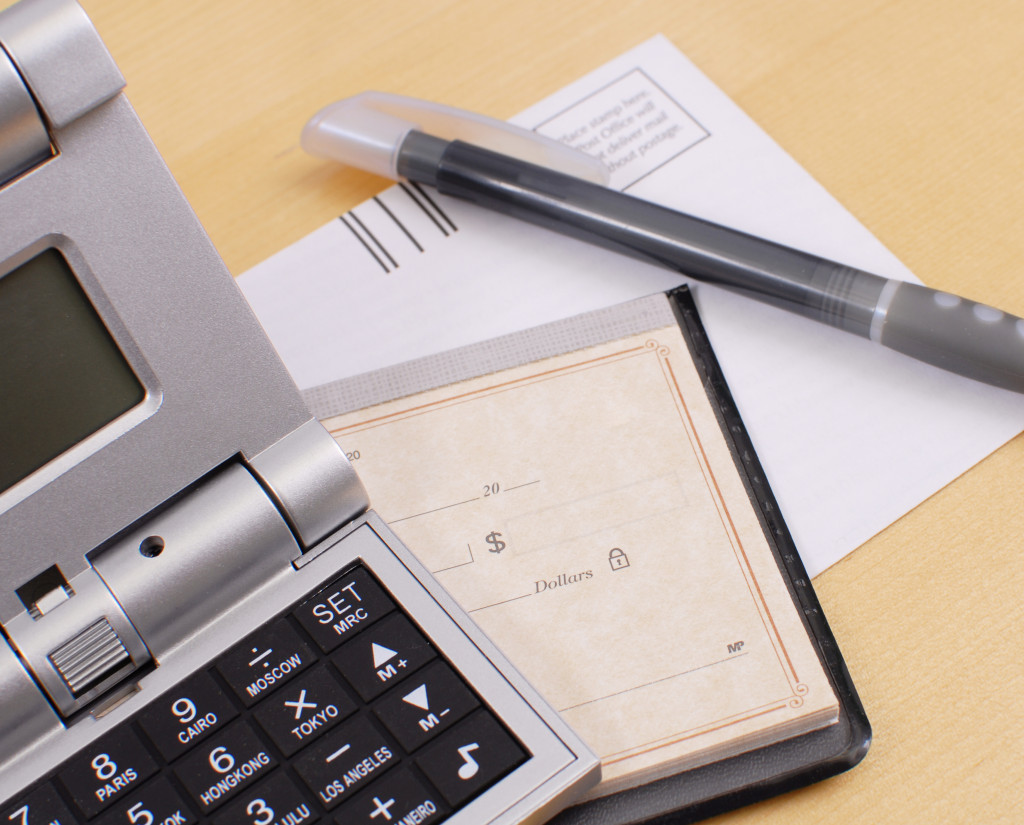 calculator, calendar, a piece of paper, and a pen on a table