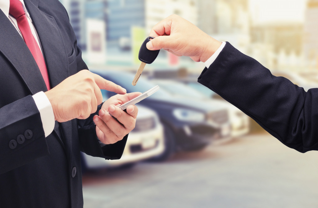 Agent giving a client the key to a car for rent.