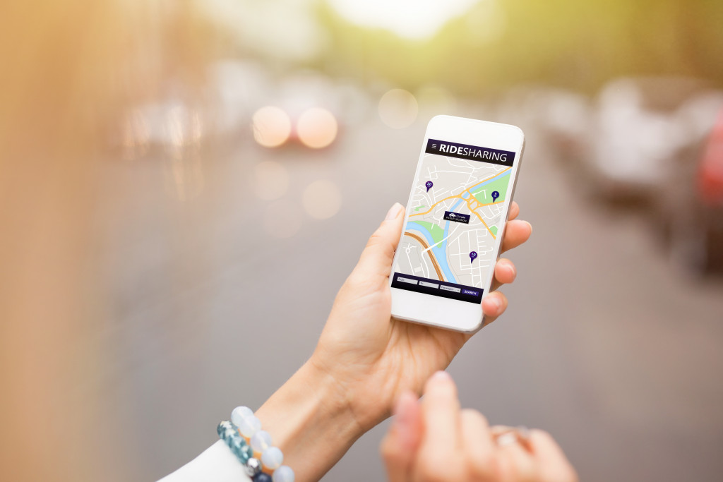 ride sharing app used by a woman on her phone
